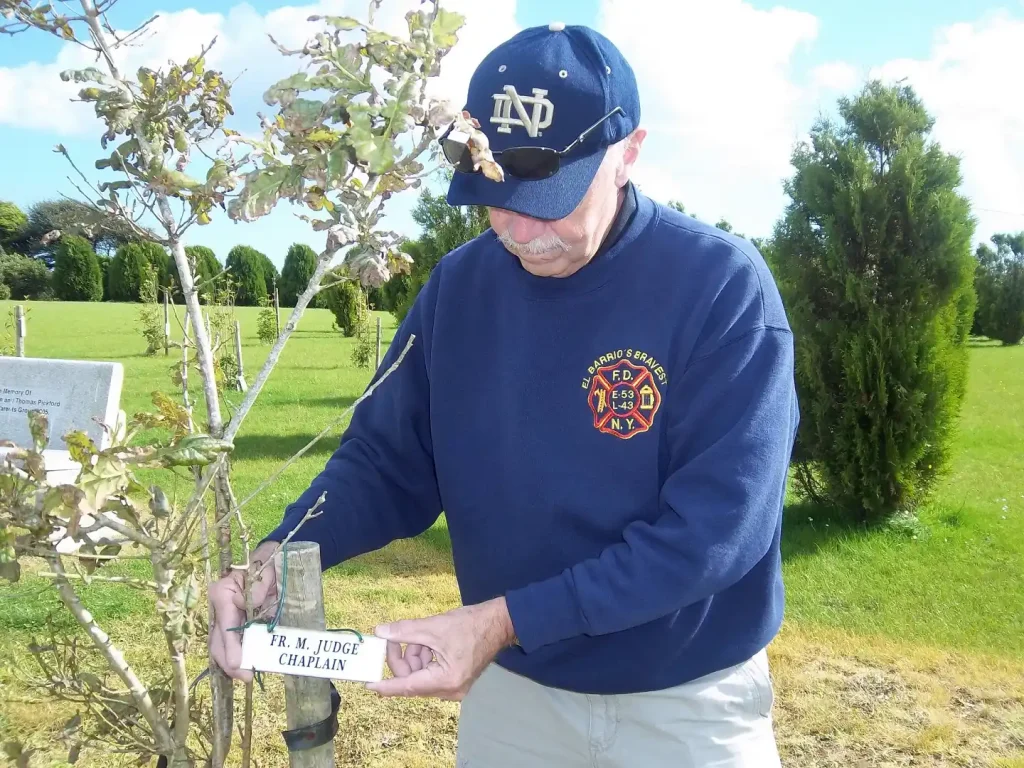 Danny Manning fixing the plaque of Fr Michal Judge on his tree in the Rinfinnan Garden of Remembrance